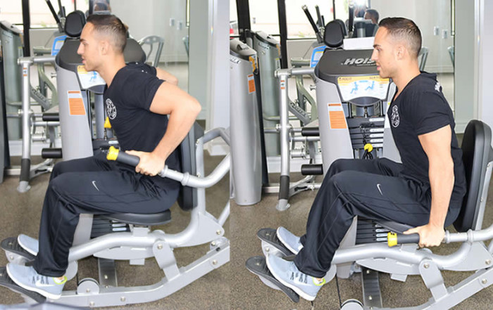 Machine tricep press performed by male personal trainer