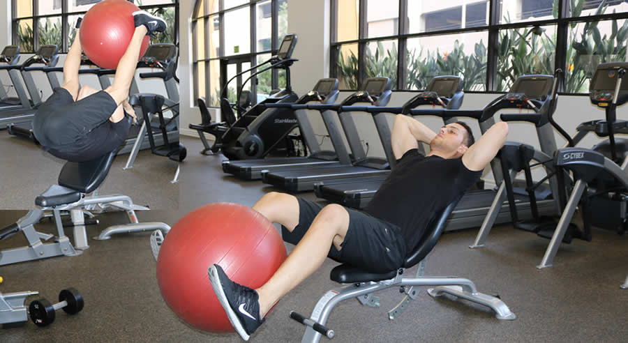 leg lift with ball on high incline performed by male personal trainer
